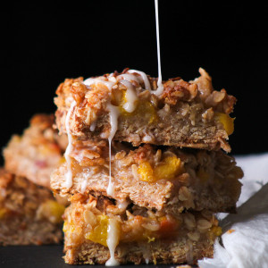 peach cobbler bars with a glaze drizzled on top.