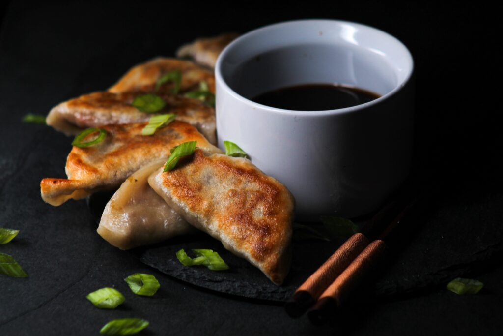 Crispy dumplings on a plate garnished with scallions.
