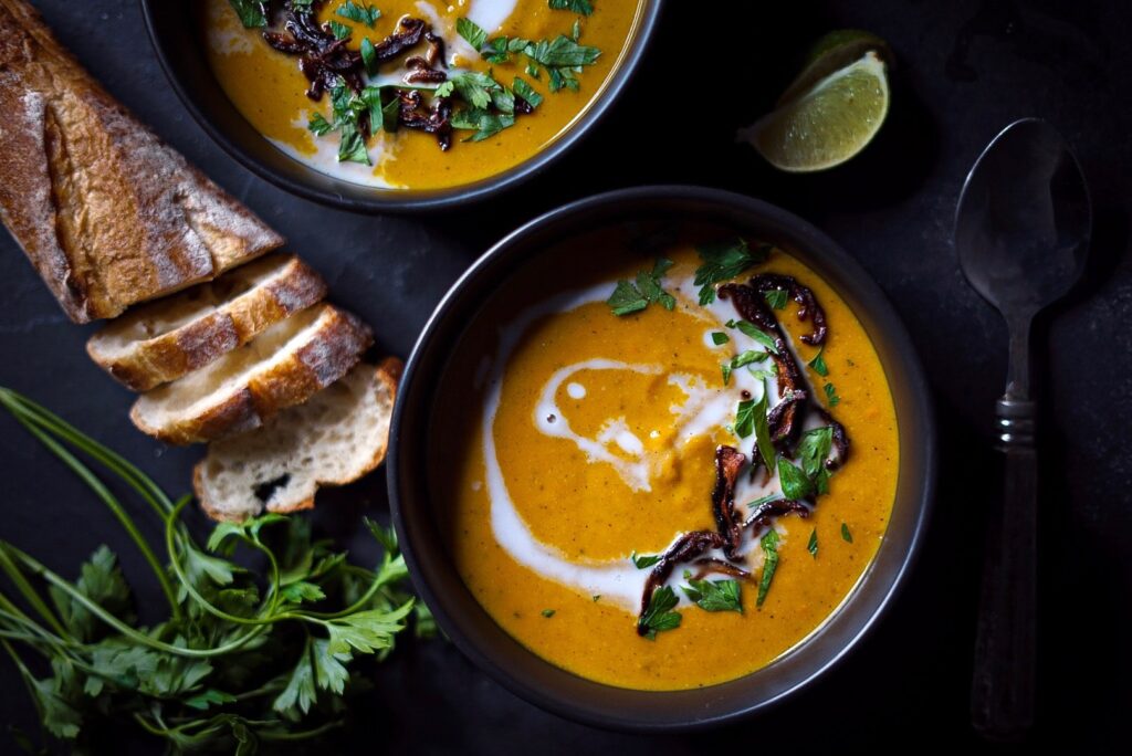 Bowl of squash soup with mushroom bacon on top.