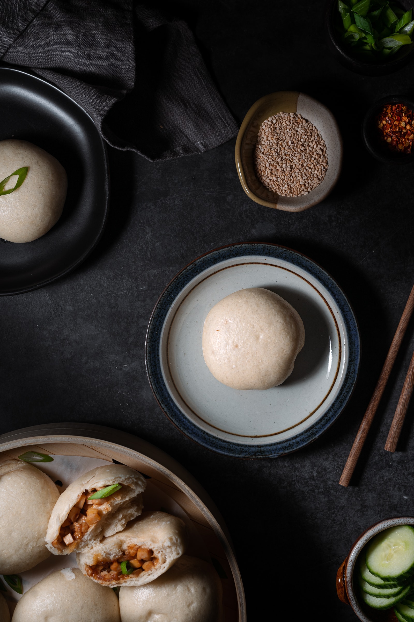 1 single steamed bun on a serving plate.