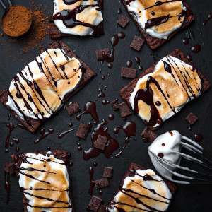 hot cocoa pop tarts surrounded by chocolate, cocoa powder and meringue topping.