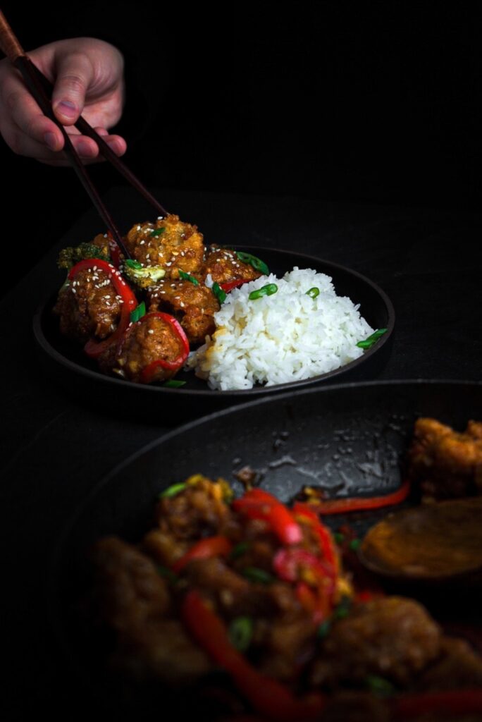 General Tso's Chicken served with rice and peppers.