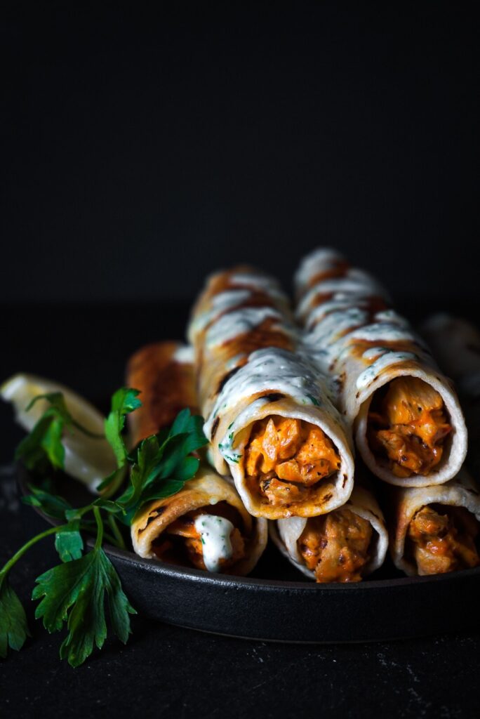 buffalo chicken taquitos stacked and drizzled with ranch.