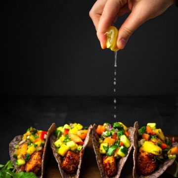 bbq crunchy shelled tacos with mango salsa on top and lemon.