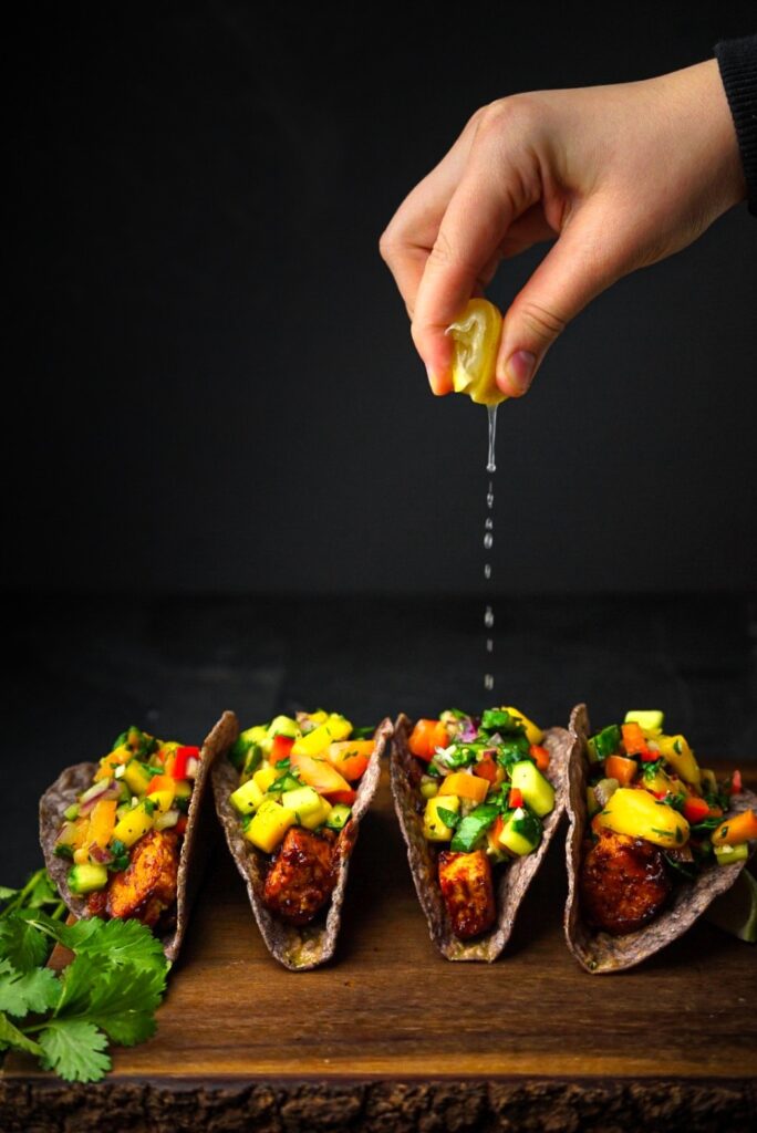 bbq crunchy shelled tacos with mango salsa on top and lemon.