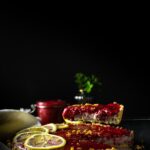 Coconut lemon tart topped with raspberry jam and lemon slices.