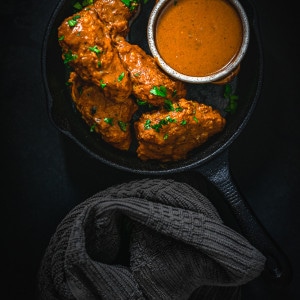 Tikka Masala Wings in a skillet with extra sauce.