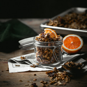Chocolate orange granola in a small jar with orange slice garnish.