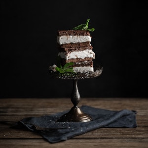 Stacked brownie ice cream sandwiches topped with mint.
