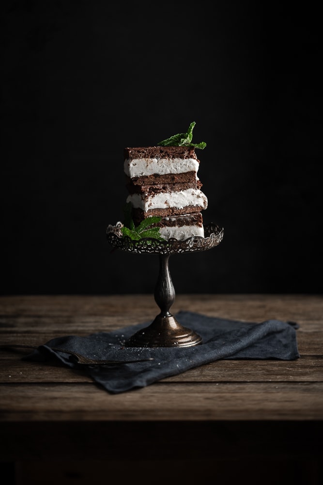 Stacked brownie ice cream sandwiches topped with mint.