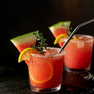 Glass of watermelon lemonade with a watermelon garnish.