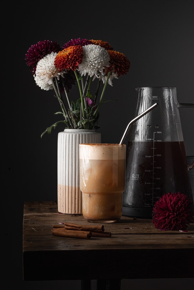 Pumpkin cold brew with flowers in the background and cold brew.