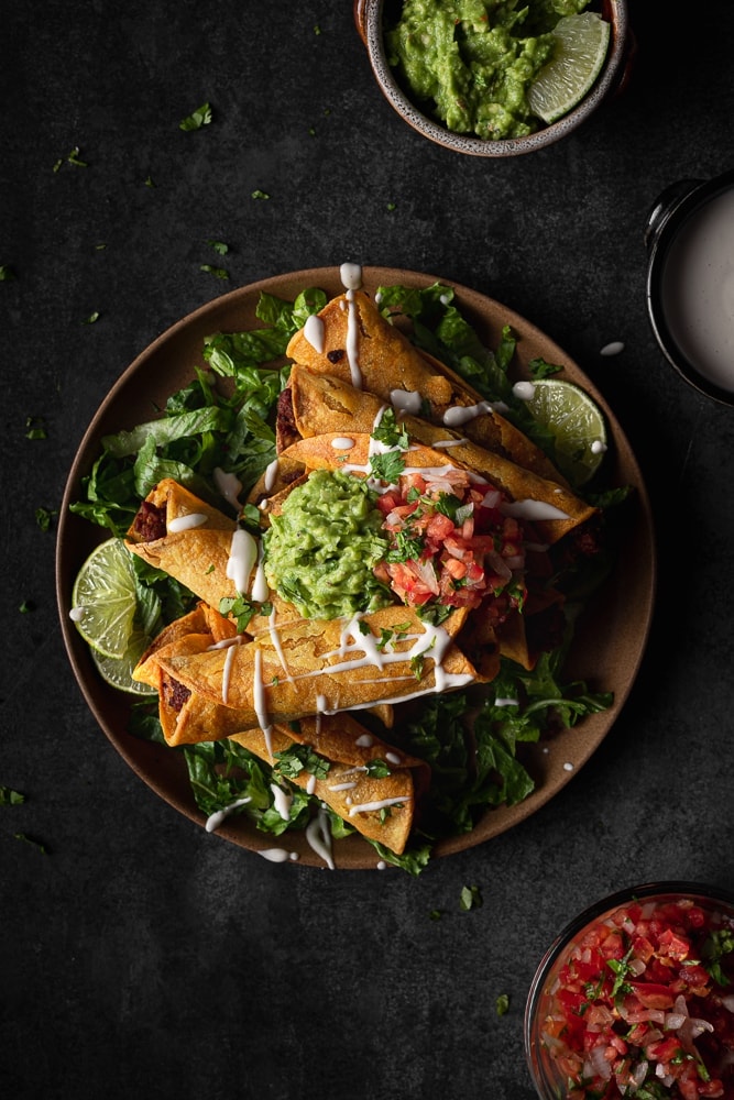 Impossible beef taquitos topped with guacamole, pico and sour cream drizzle.