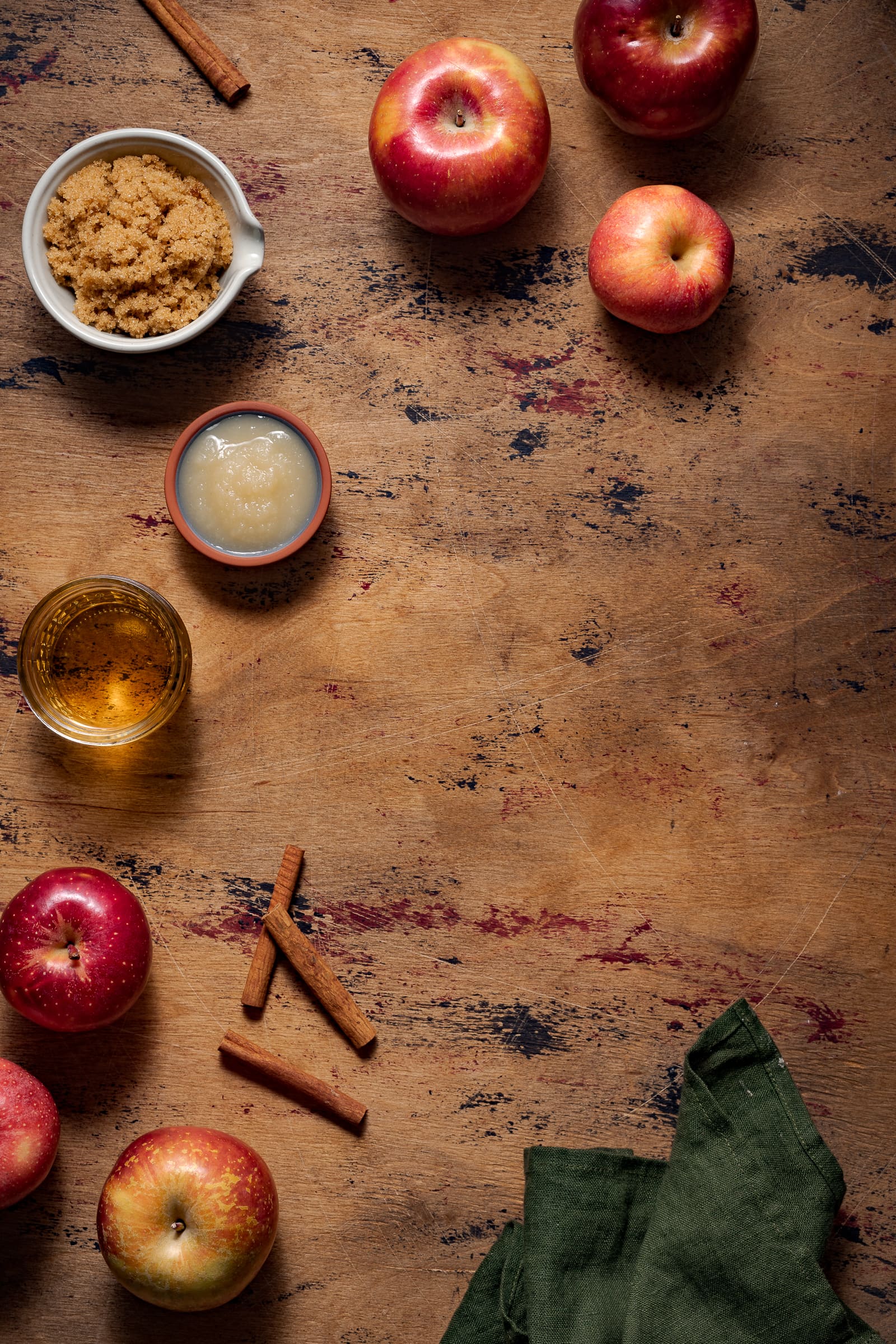 Apple brown sugar syrup ingredients on a wooden backdrop.