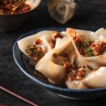 bowl of vegan beef wontons with chili oil drizzled over top