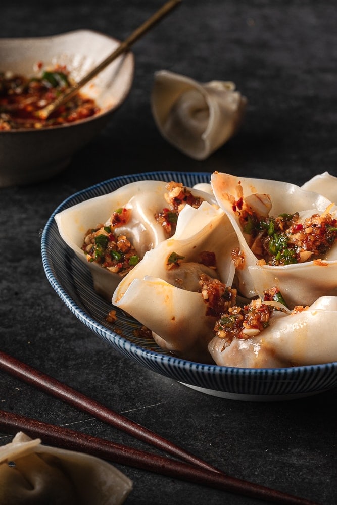 bowl of vegan beef wontons with chili oil drizzled over top