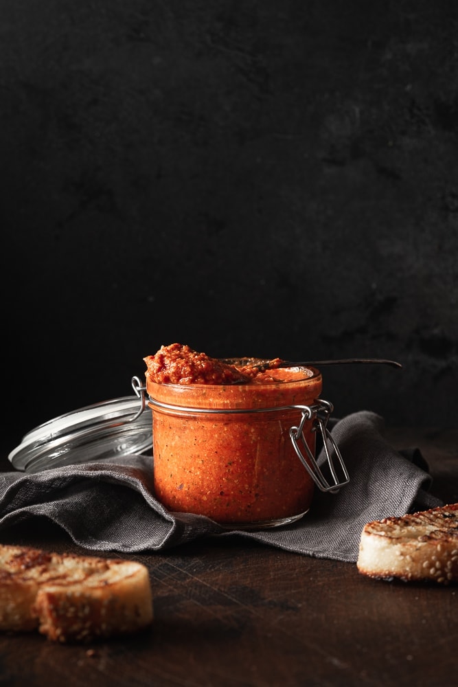 romesco sauce in a small jar with toasted bread.