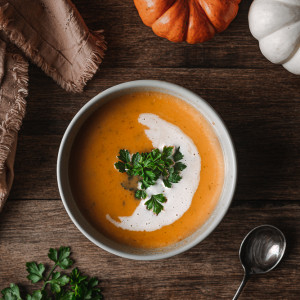Bowl of Roasted Winter Squash Soup garnished with parsley and coconut cream swirl