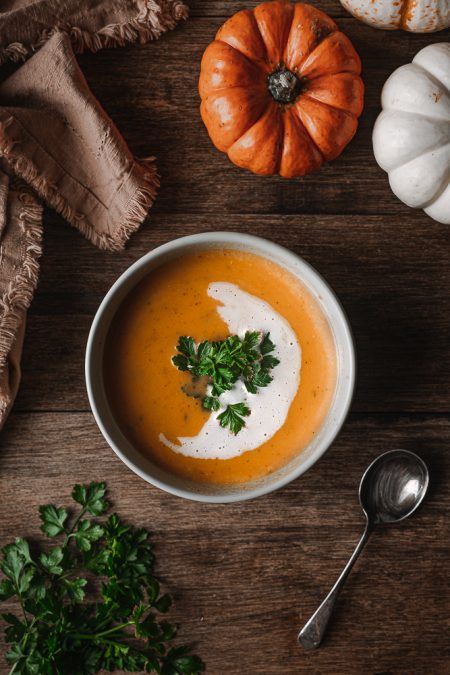 Bowl of Roasted Winter Squash Soup garnished with parsley and coconut cream swirl