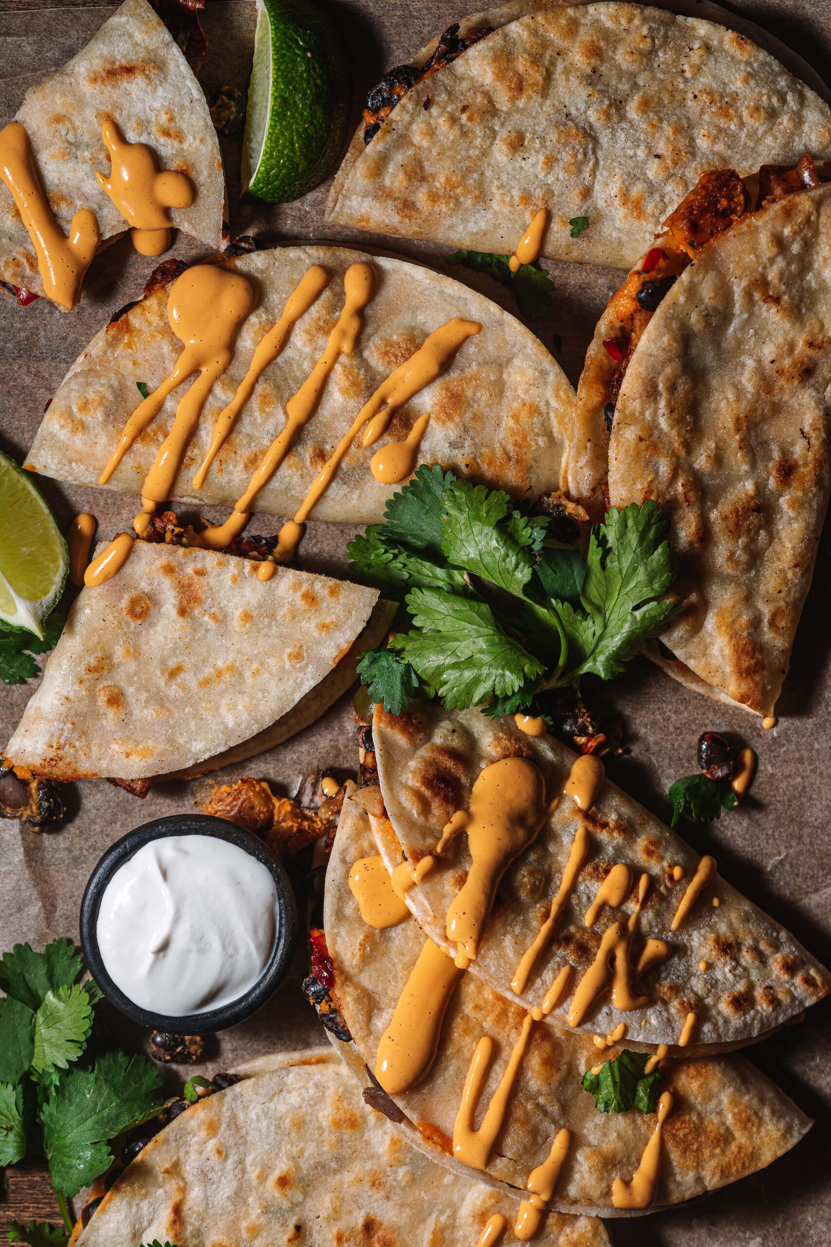 close up of crispy tacos with cheese sauce drizzled over top