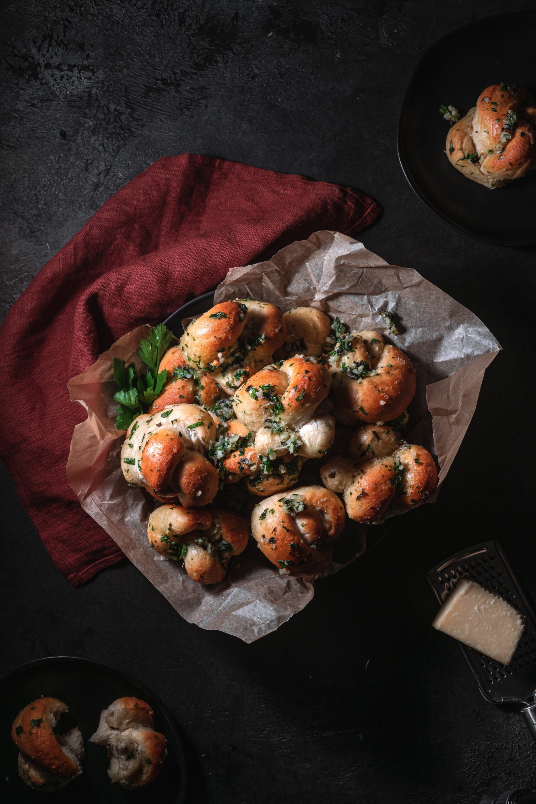 plate of garlic knots topped with fresh parsley and vegan Parmesan.