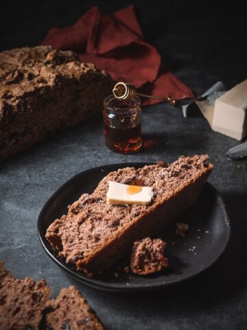 loaf of soda bread on a serving plate with butter.