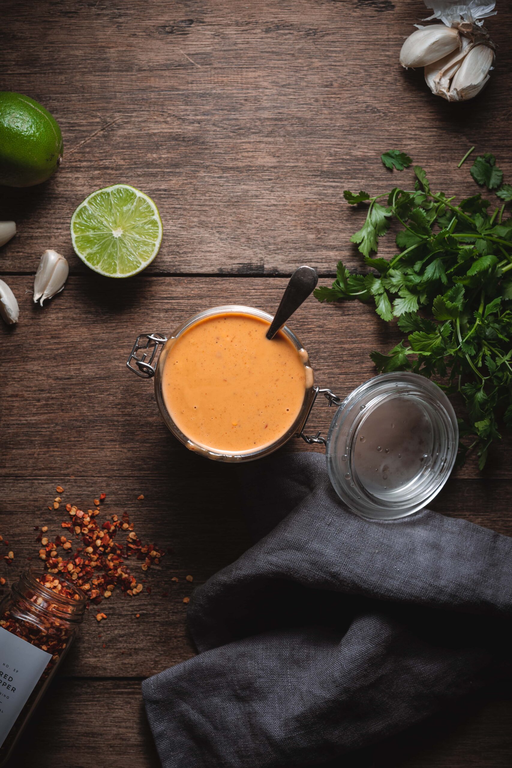 easy 5 minute thai peanut sauce surrounded by chili flakes, lime, and cilantro.