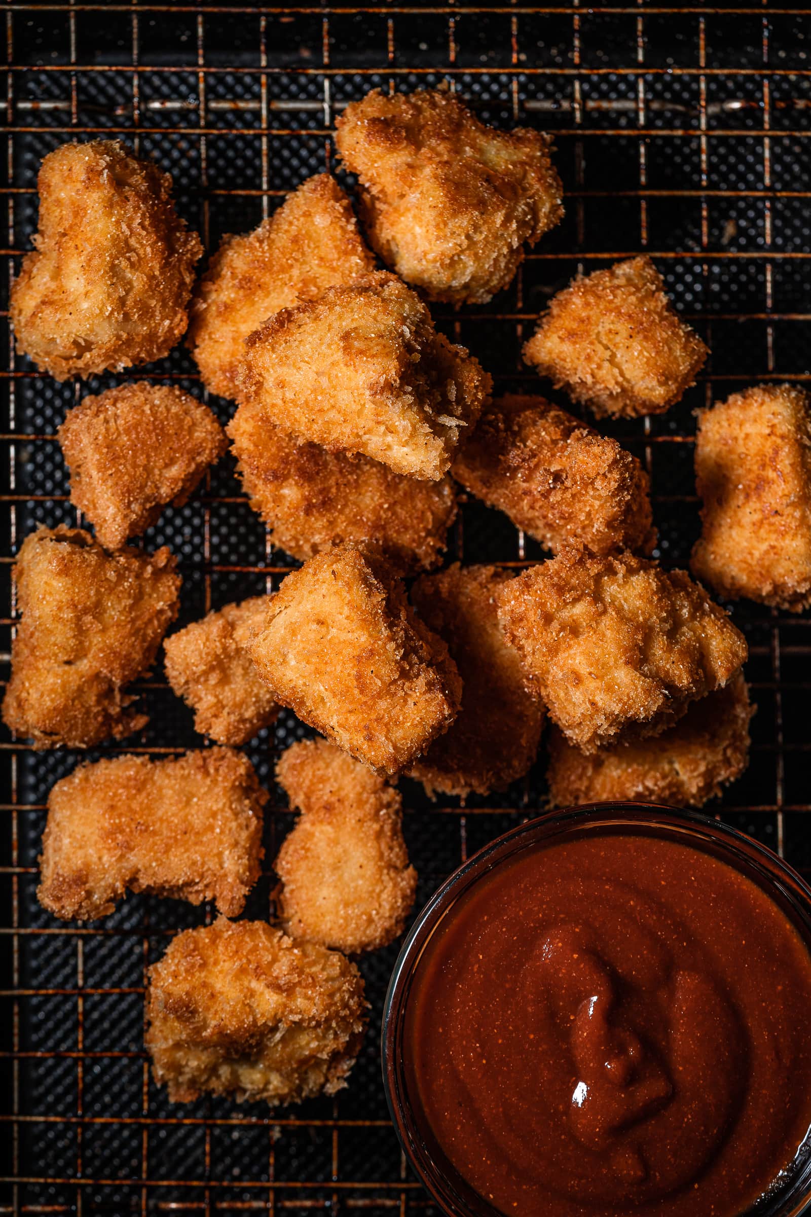 tofu nuggets on a wire rack with bbq sauce.