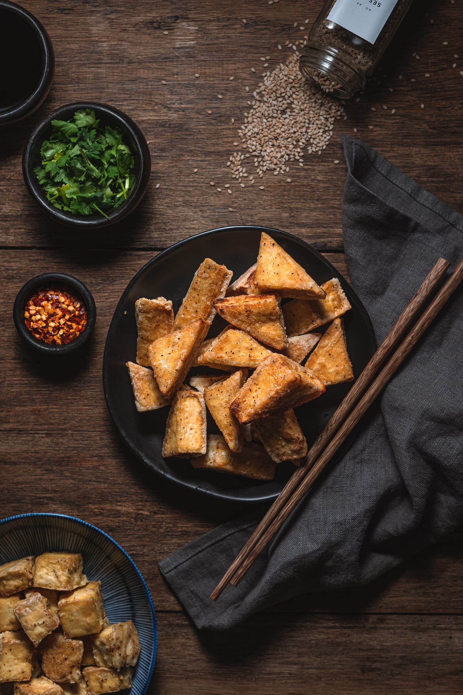 Cooked Crispy Tofu cut in to triangles on a serving plate.