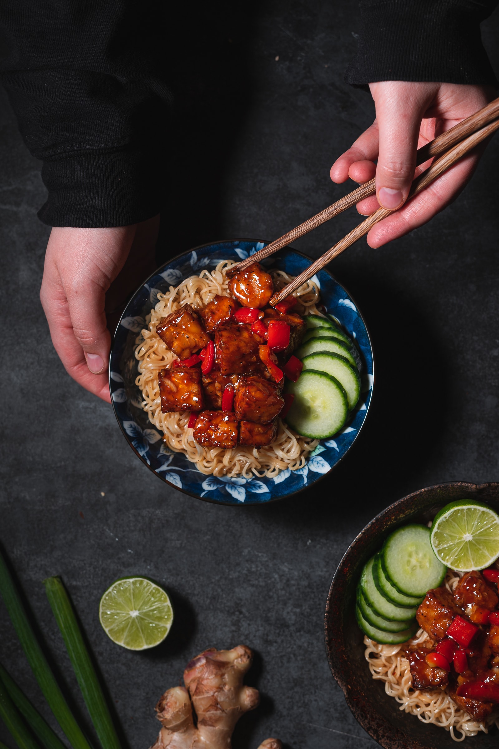 General Tso's Tempeh in a bowl with chopsticks.
