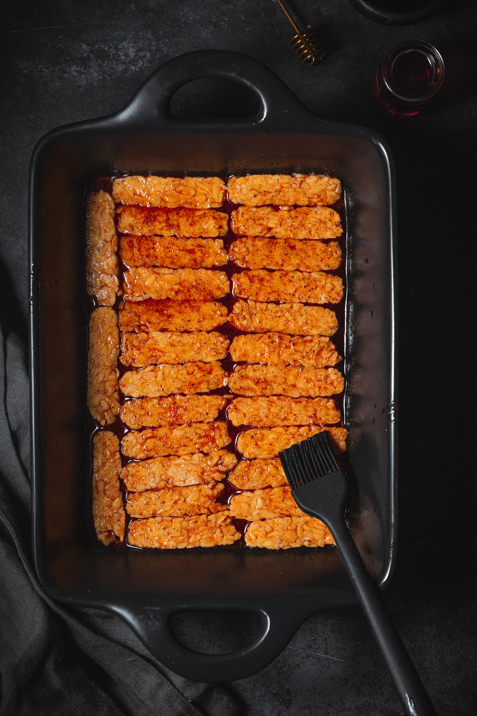tempeh in a large baking dish with a marinade poured over.