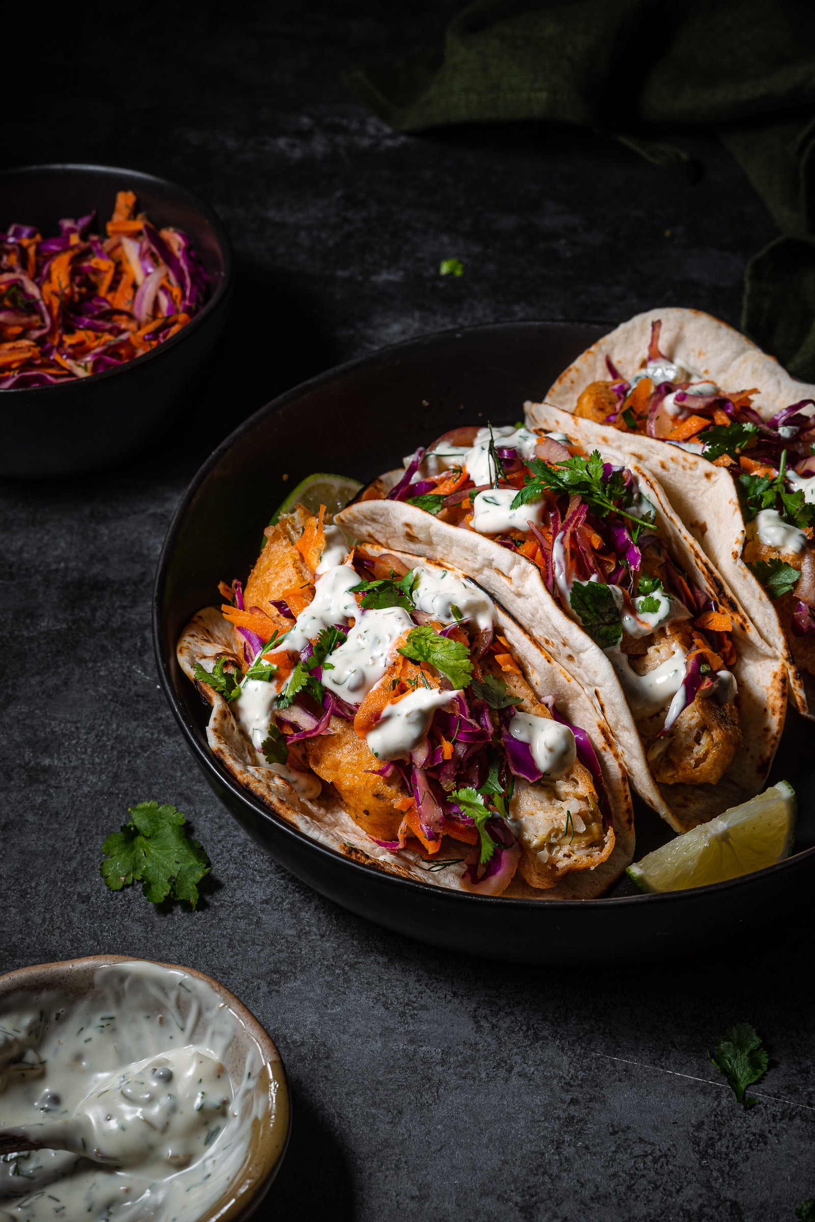 Vegan fish tacos topped with red cabbage slaw and garnished with cilantro.