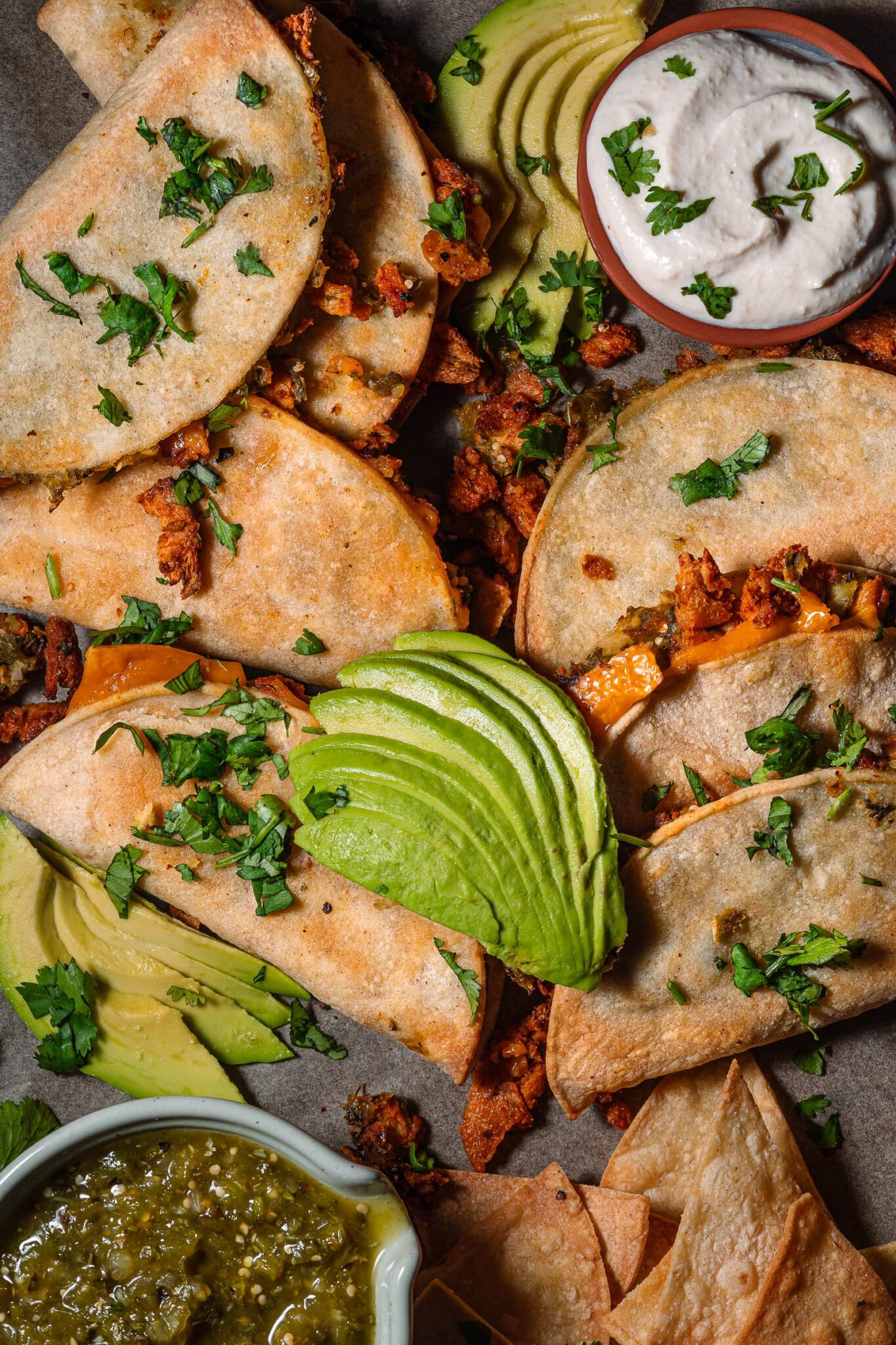 close up of vegan crispy tacos with avocado and sour cream.