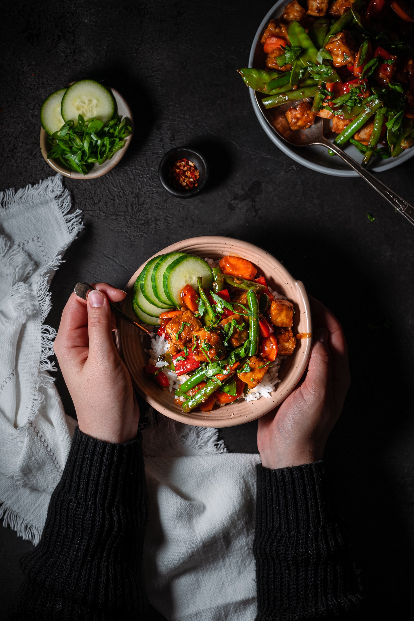 Bowl of teriyaki tofu stir fry garnished with green onion and scallions.