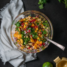 pineapple mango salsa in a bowl with lime and cilantro.