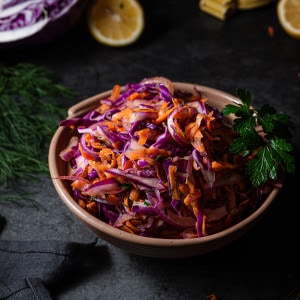 red cabbage slaw in a bowl garnished with parsley.