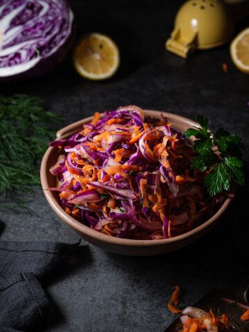 red cabbage slaw in a bowl garnished with parsley.