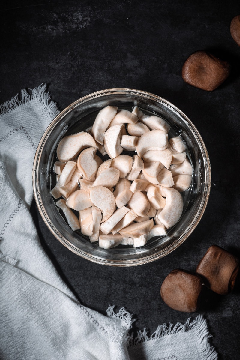 Sliced mushrooms in a bowl with water.