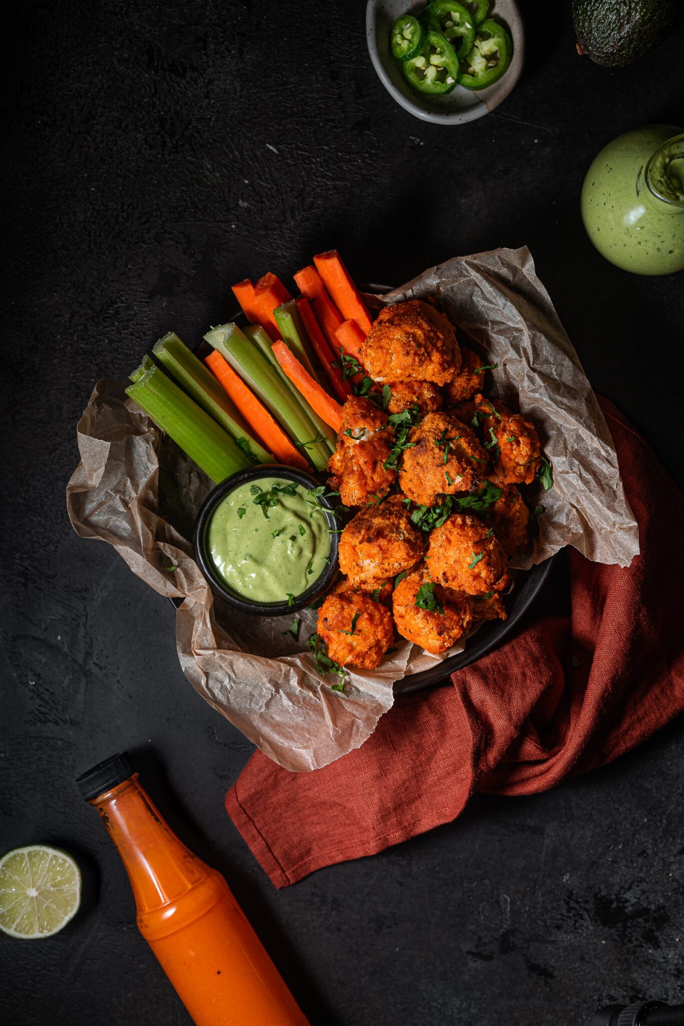 buffalo cauliflower in a serving dish with carrots and celery.