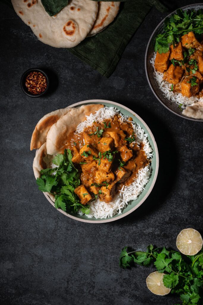 Butter chicken with tofu over basmati rice, cilantro and fresh naan.