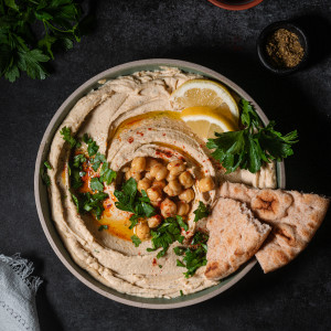 Chickpeas on a plate with parsley, smoked paprika and chickpeas as a garnish with flatbread.