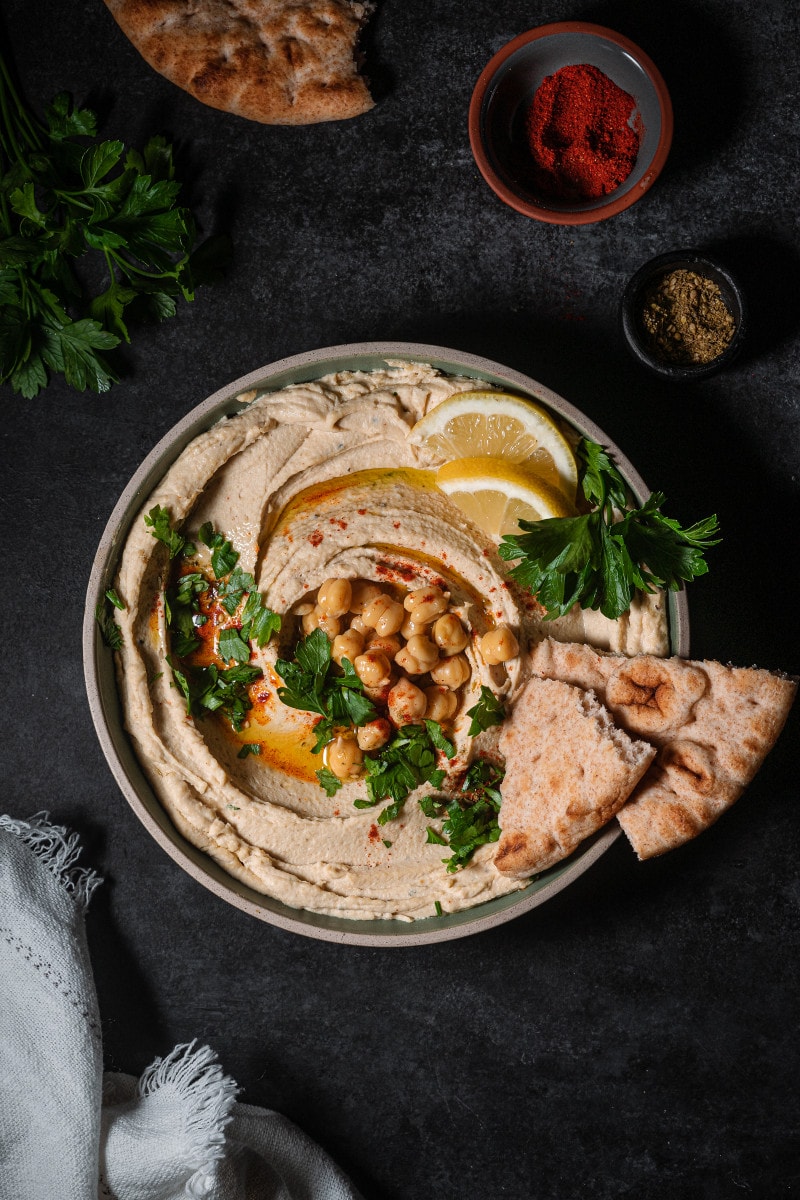 Chickpeas on a plate with parsley, smoked paprika and chickpeas as a garnish with flatbread. 