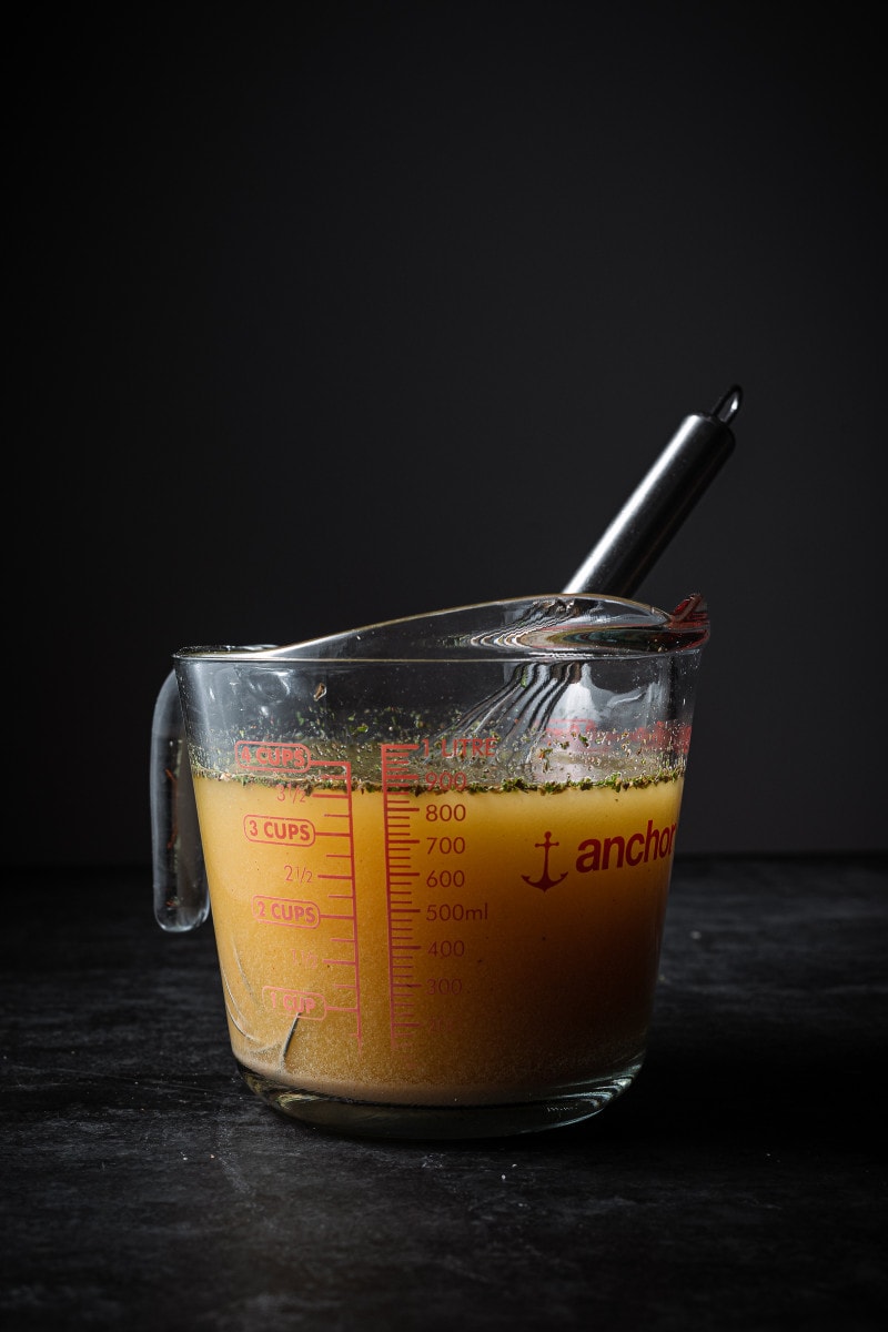 Vegan chicken stock in a measuring cup.