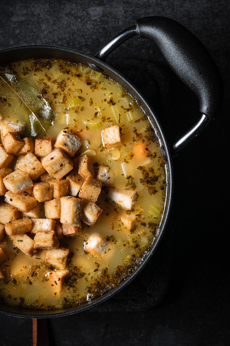 Baked cubed tofu being added to the soup.