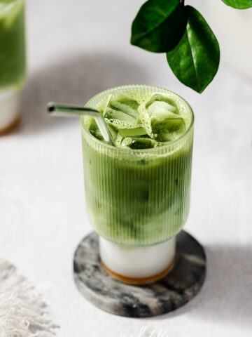 matcha in a glass cup on a marble coaster.