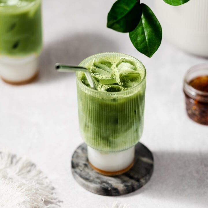 matcha in a glass cup on a marble coaster.
