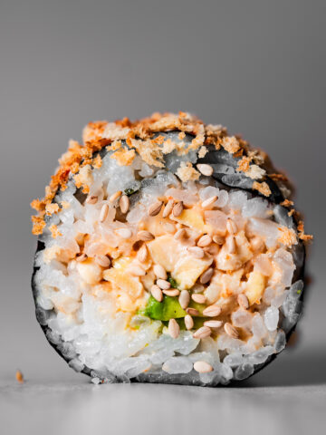 close up shot of a sushi roll with panko crisp topping.