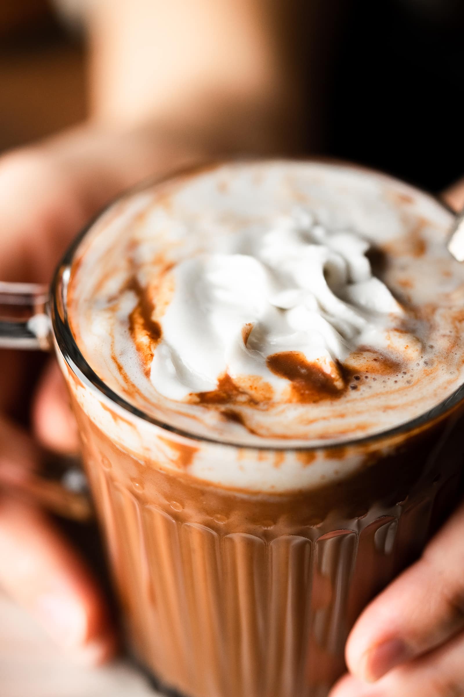 Hot chocolate close up with melted coconut whipped cream.