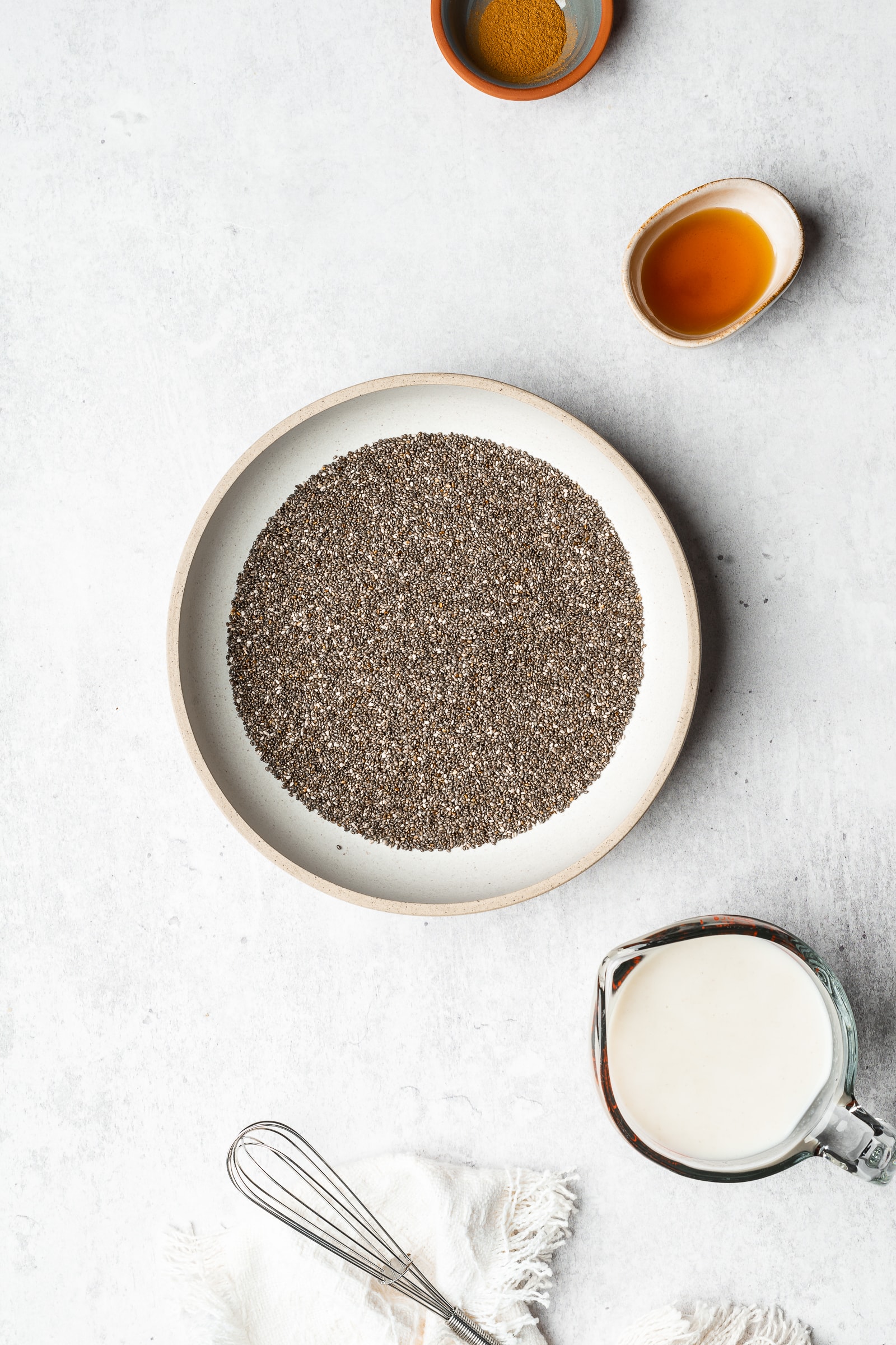 Chia seed with oat milk ingredients on a gray backdrop.