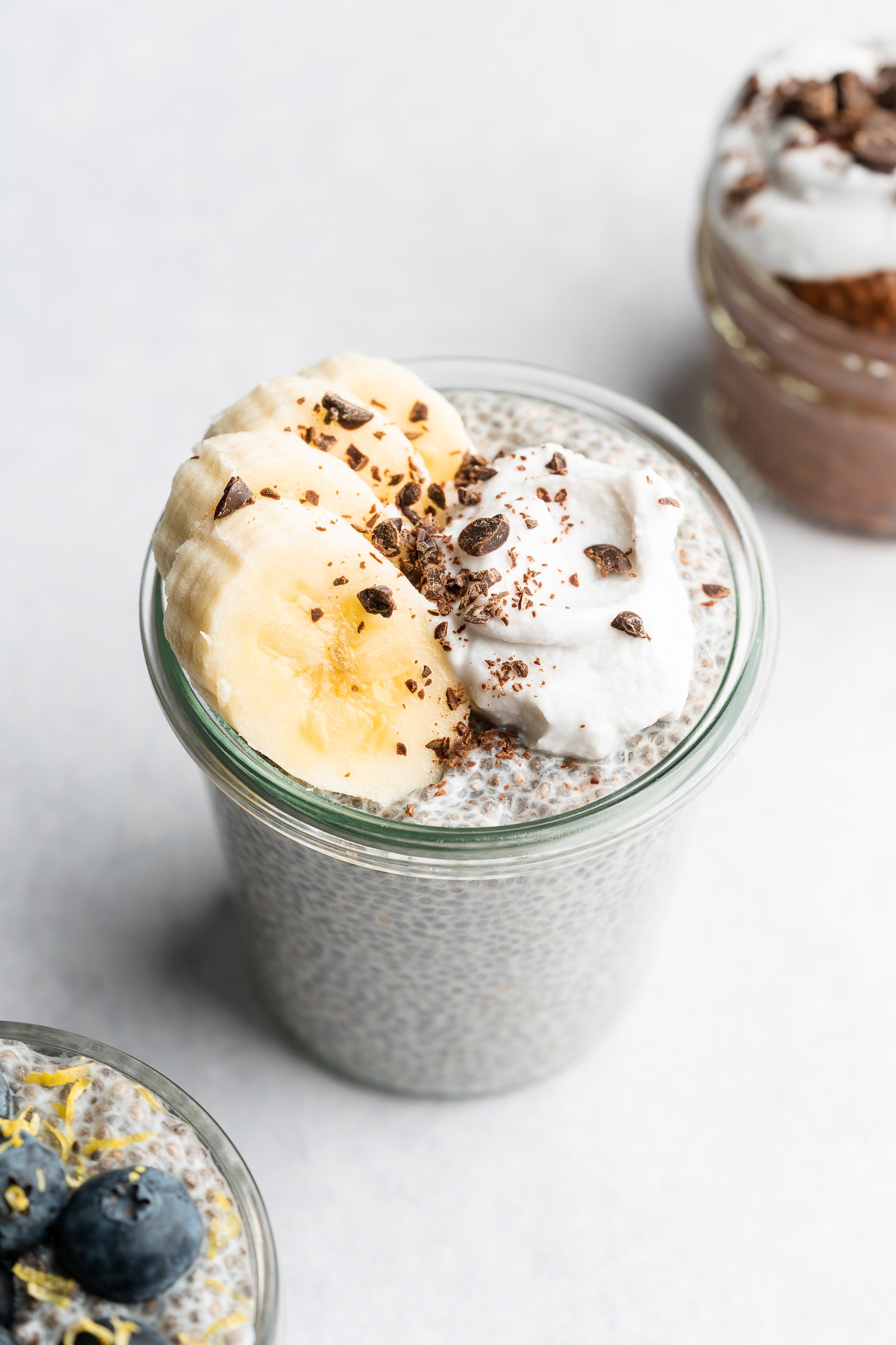 Chia seed pudding topped with banana slices, coconut whip, and chocolate chips.